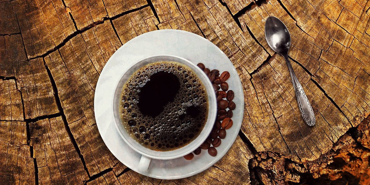 Tasse Kaffee schwarz auf Holz Hintergrund