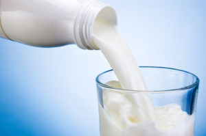 Milch wird in ein Glas gefüllt