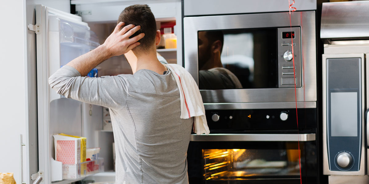 Mann vor offenem Kühlschrank