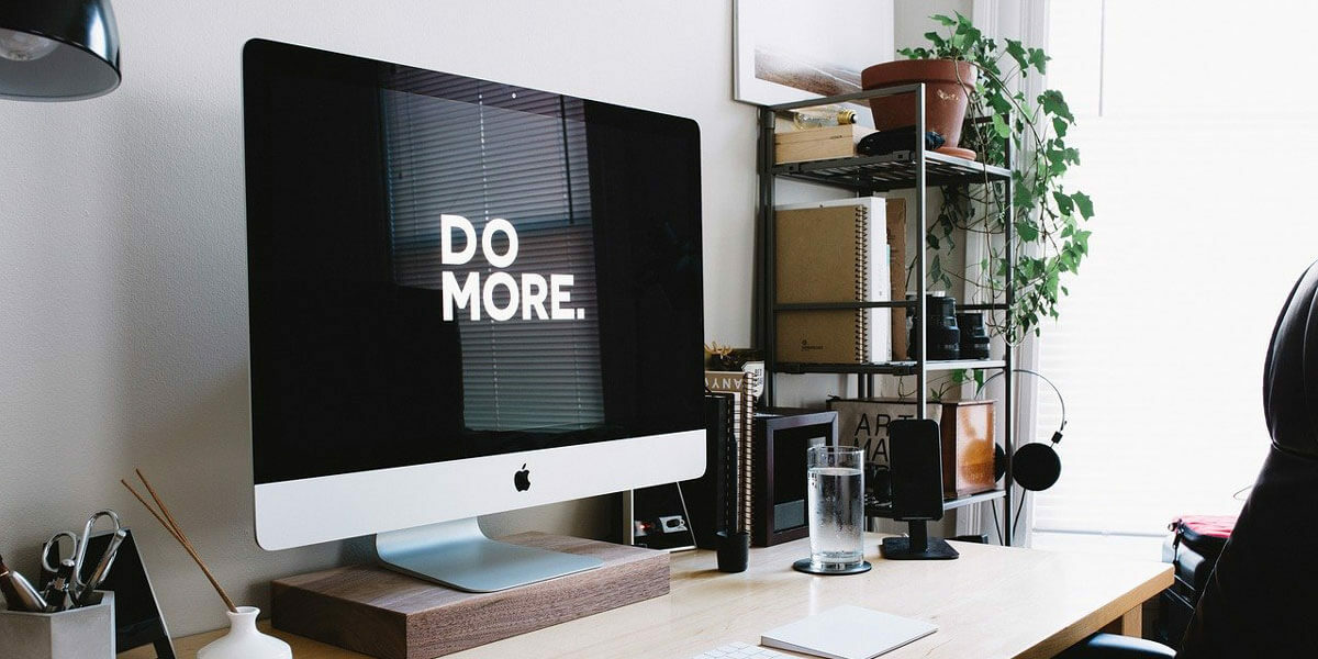 Apple Monitor auf Schreibtisch, Display zeigt "Do more"